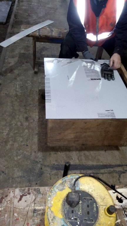 Class 127: Removing the protective plastic from a grey wall panel